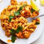 A plate of blackened shrimp alfredo pasta.