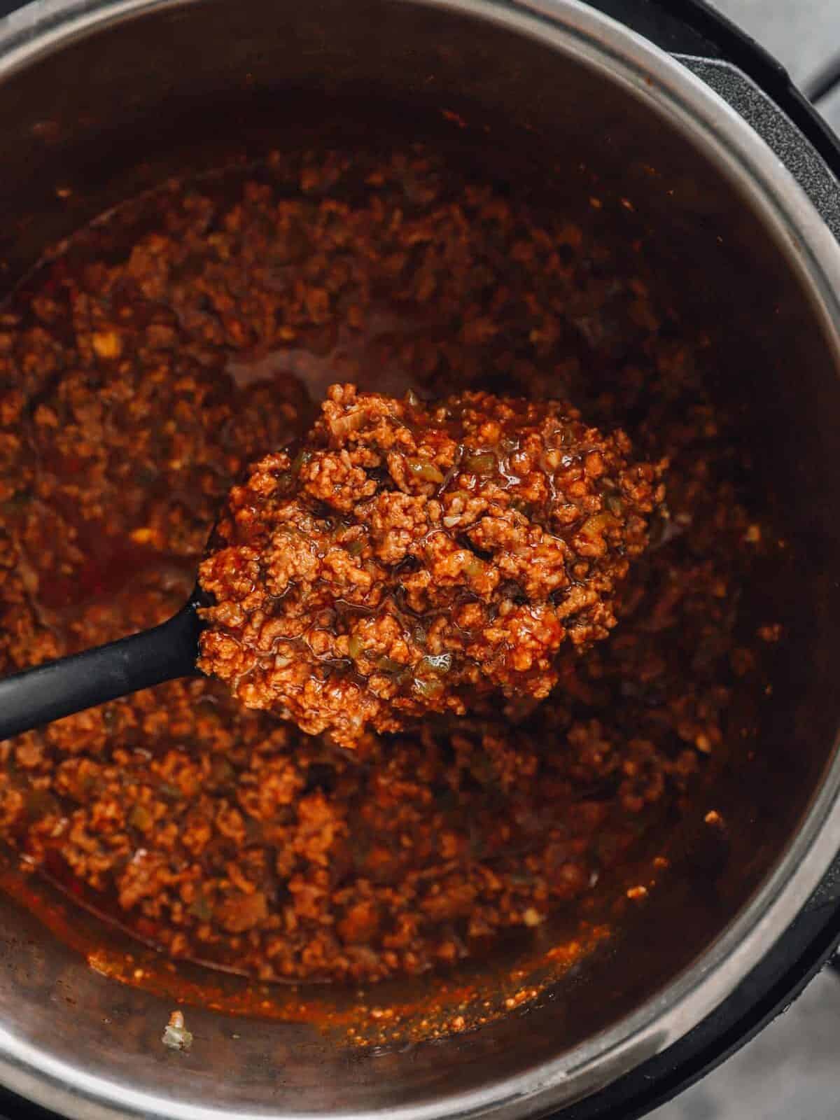 a spoon lifting a scoop of sloppy Joe meat out of an instant pot