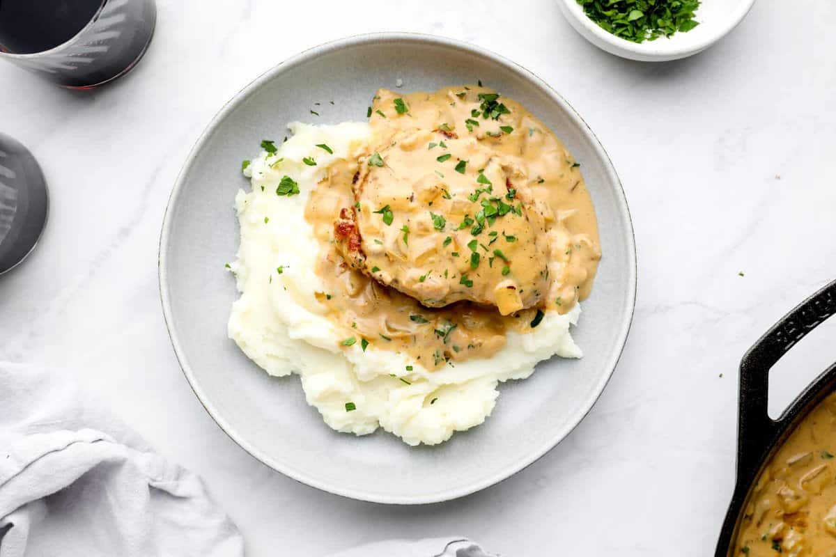 plate of smothered pork chops at the center of a table scape