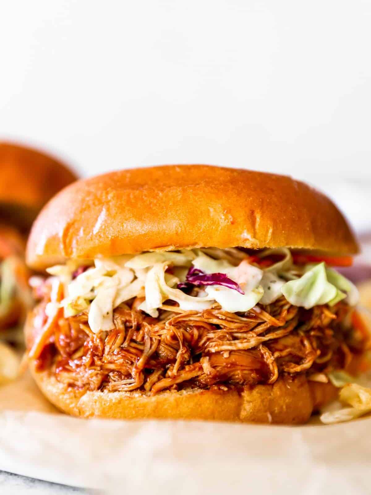 crockpot pulled bbq chicken on a sandwich with coleslaw 