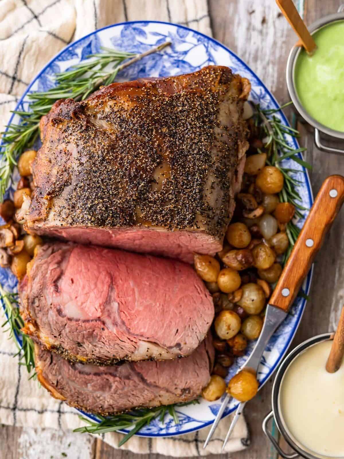 overhead view of a roast on a serving platter surrounded by potatoes