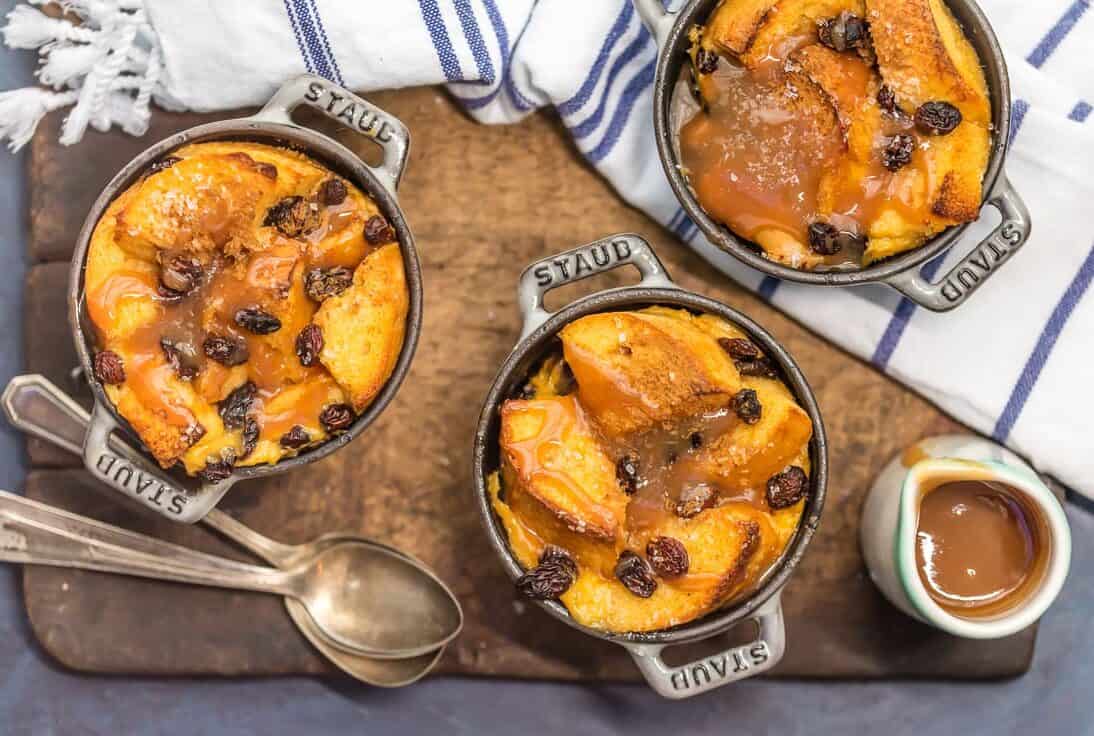 individual sized Irish bread puddings on a tabletop with spoons 