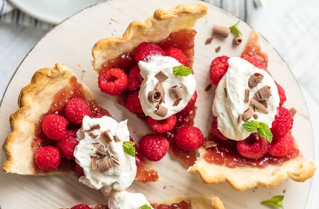 Raspberry tarts made with raspberry jam, fresh raspberries, and whipped topping