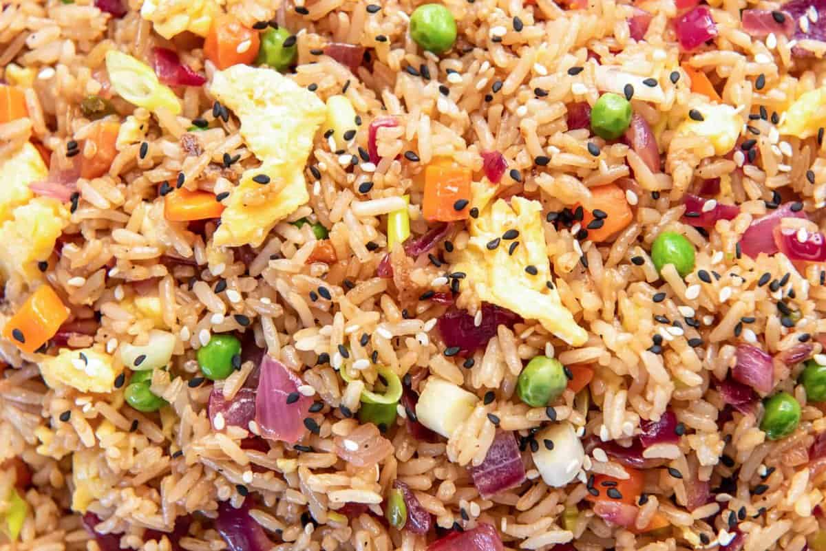 close up view of fried rice filled with bits of carrot, peas, onions, and scrambled eggs.