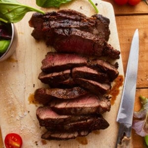 overhead view of sliced ribeye steak on a cutting board.