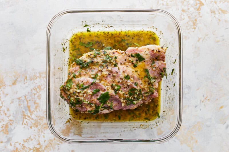marinated pork shoulder in a glass bowl.