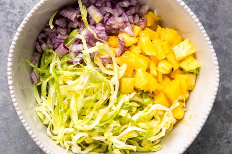 Pineapple cabbage slaw in a mixing bowl.