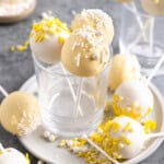 A collection of lemon cake pops arranged in glasses and on a plate.