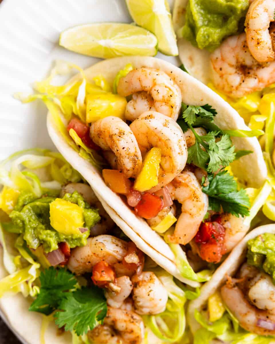 Overhead view of a plate of street tacos with shrimp and slaw.