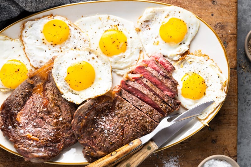steak n eggs on a white serving dish.