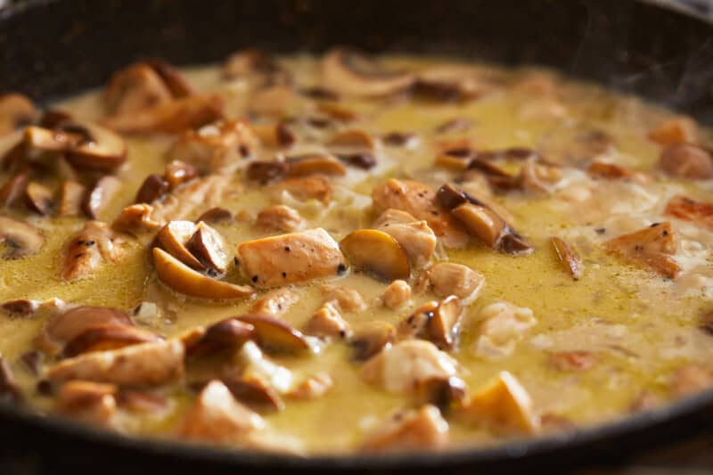 chicken and mushrooms in creamy sauce in a pan.