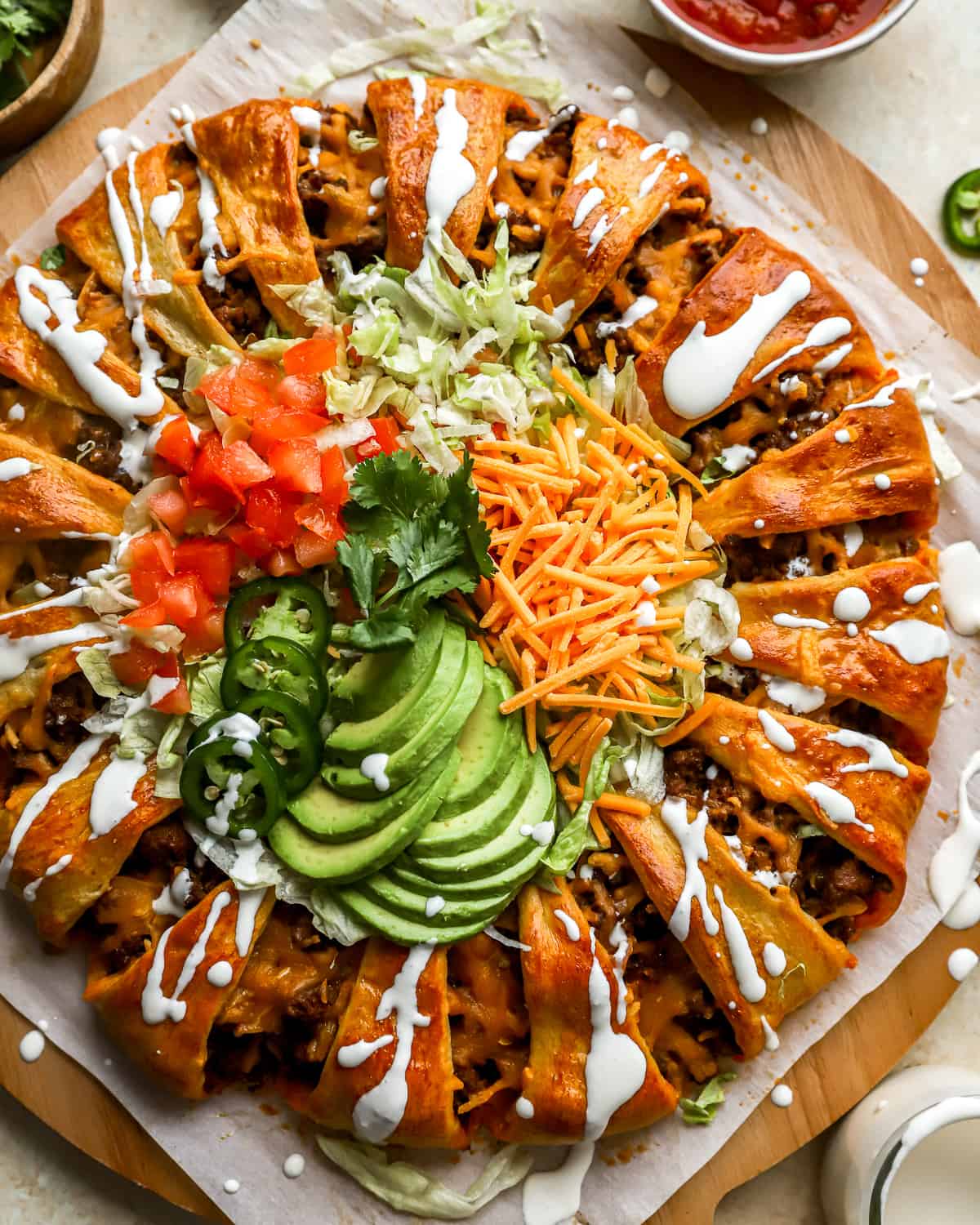 overhead view of a taco ring drizzled with sour cream.