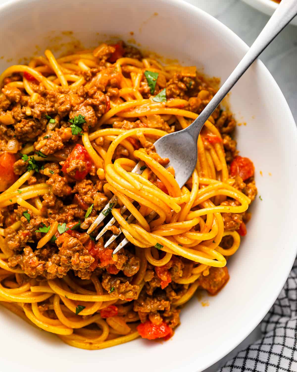 a fork twirling pasta in a bowl of taco spaghetti.