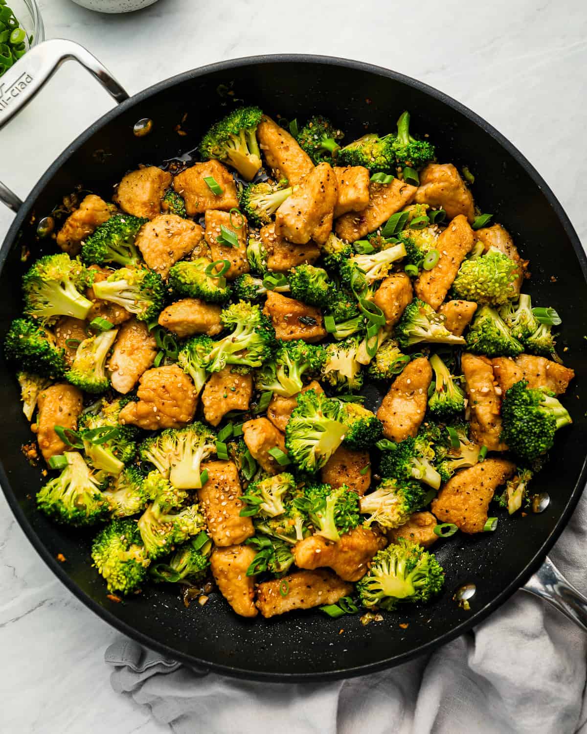 Chicken and broccoli stir fry in a skillet.