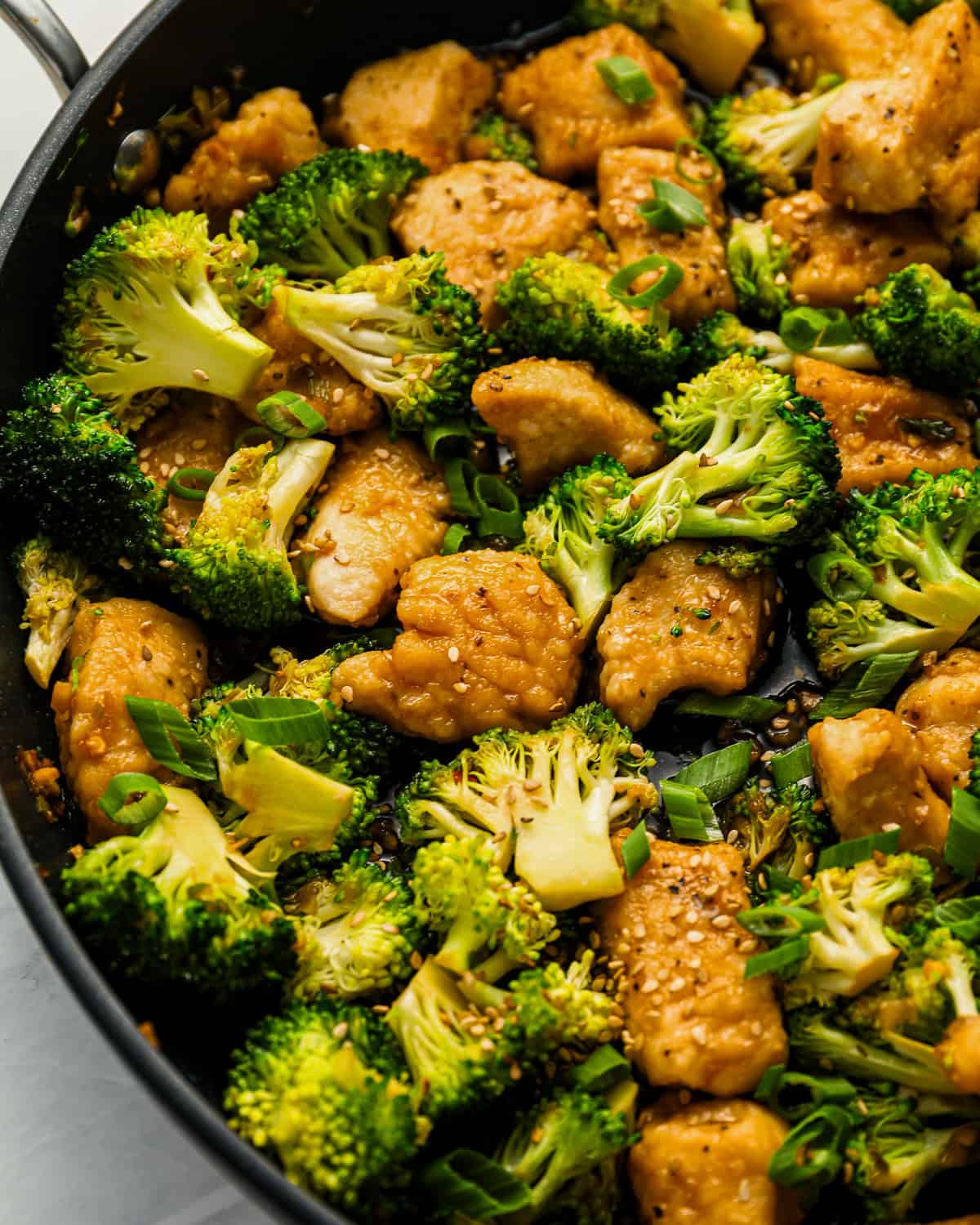 Close up on a stir fry with chicken and broccoli.