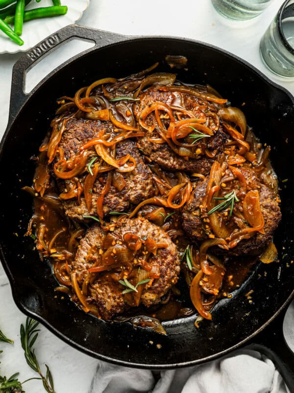 overhead view of cube steaks in gravy in a pan.