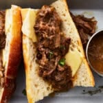 a hot beef sandwich on a split roll with cheese.