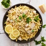 overhead view of lemon chicken pasta in a pan with lemon slices.