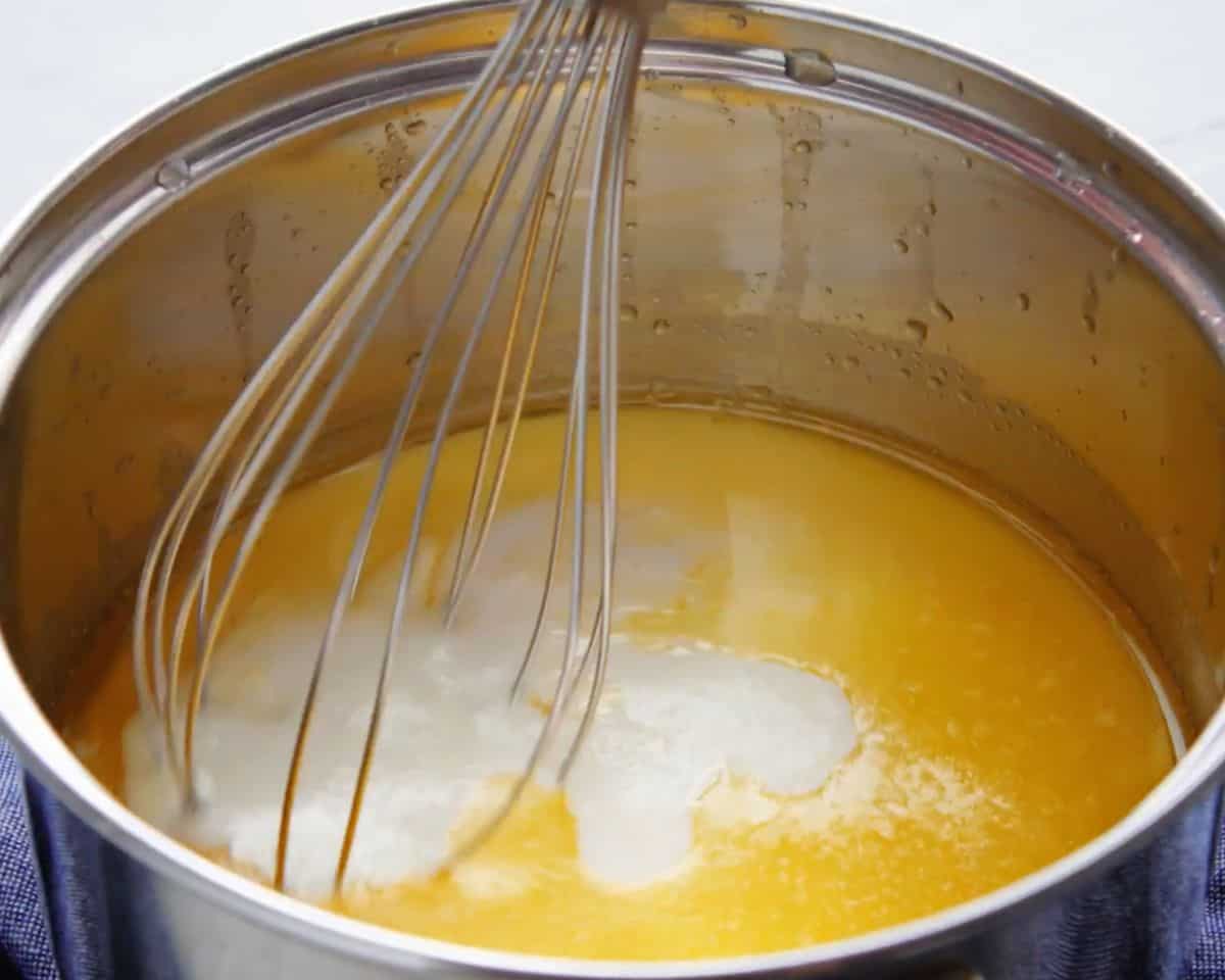 whisking cream to make homemade alfredo sauce