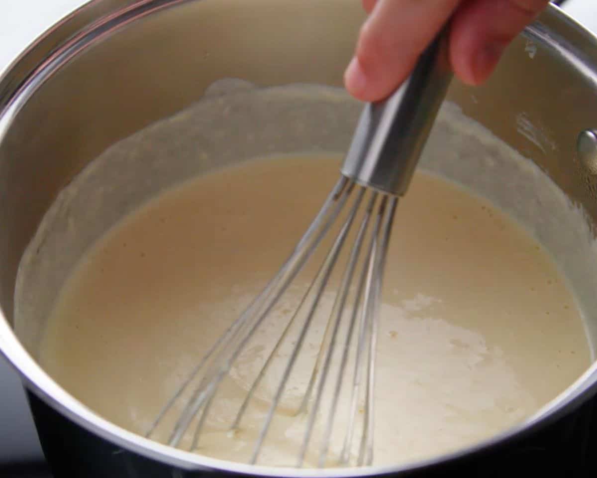 whisking homemade alfredo sauce