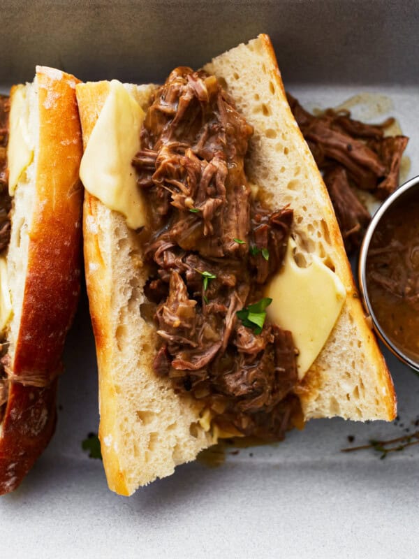 a hot beef sandwich on a split roll with cheese.