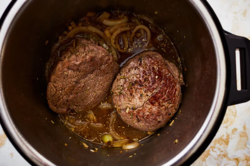 seared chuck roast and onions in a pressure cooker.