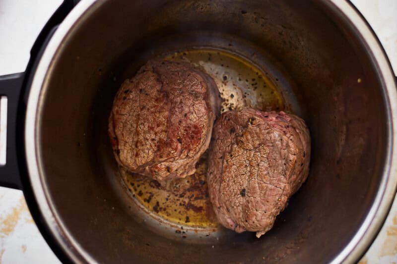 2 pieces of seared beef in a pressure cooker.