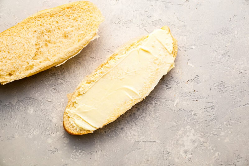 the bottom half of an open sub roll slathered with mayonnaise.