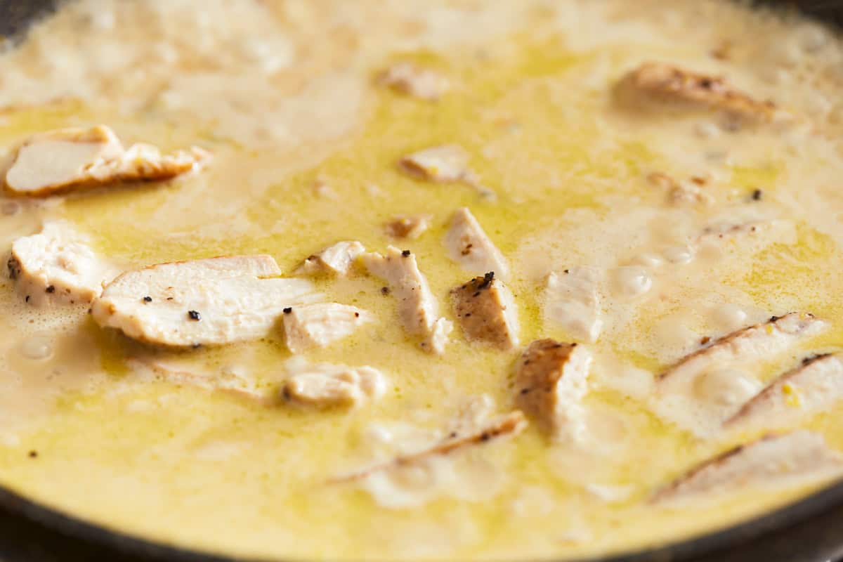 sliced chicken in creamy lemon sauce in a pan.