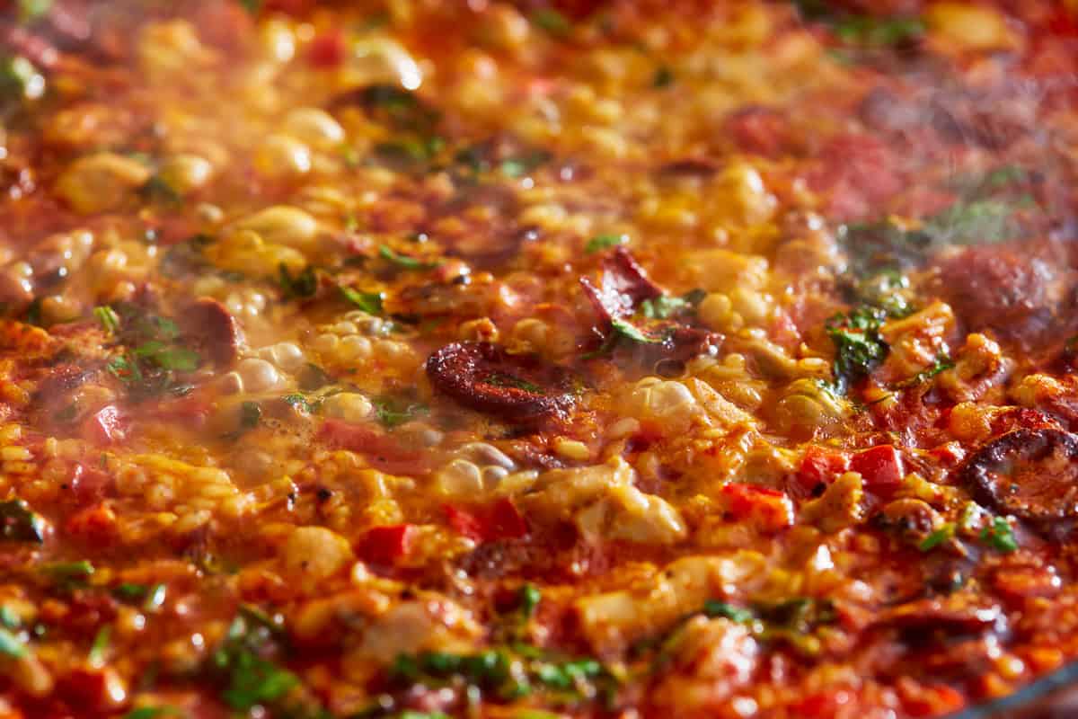 seasoned paella bubbling in a pan.