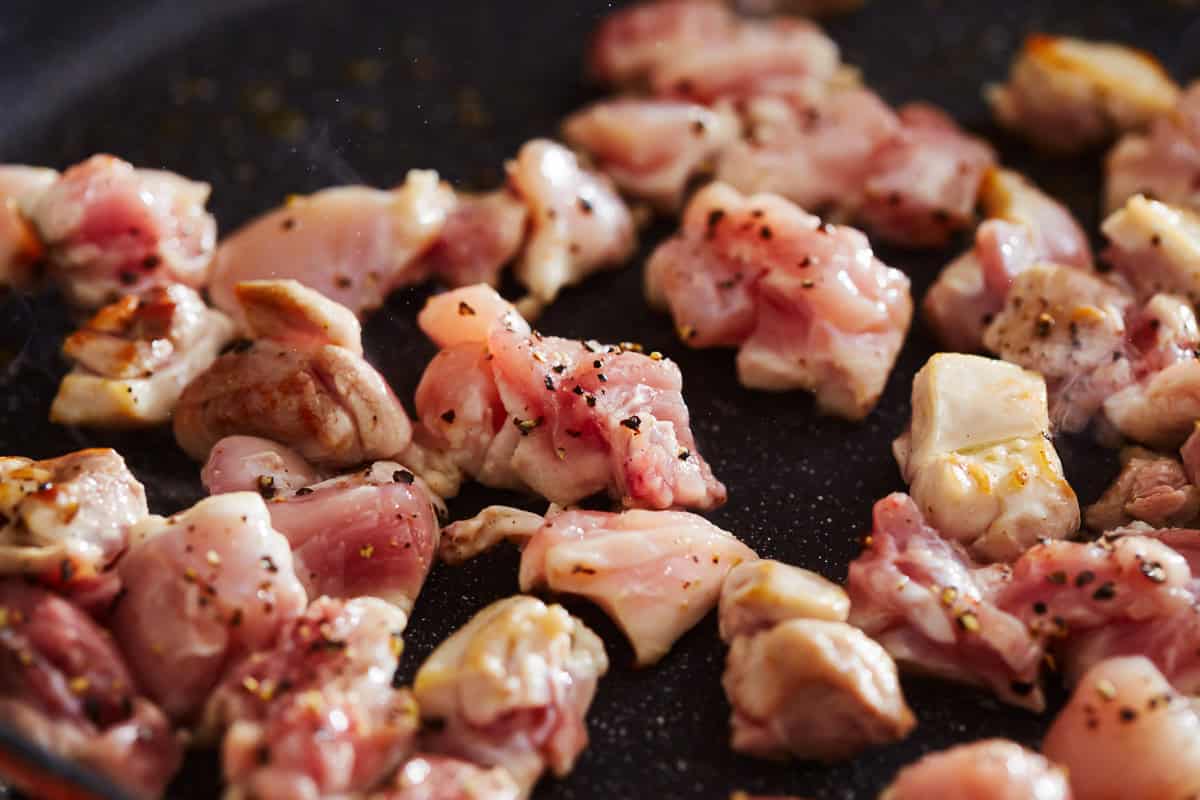 chicken cooking in a pan.