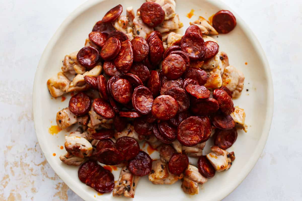 cooked chicken and chorizo on a white plate.