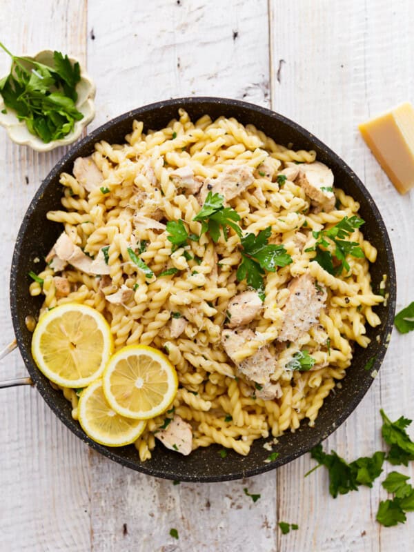 overhead view of lemon chicken pasta in a pan with lemon slices.