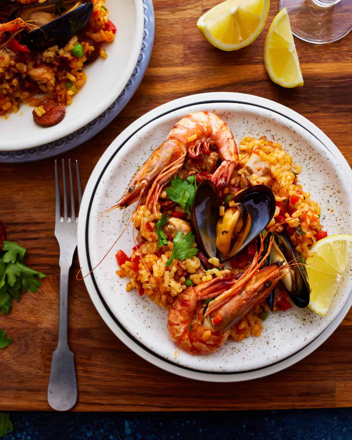 overhead view of a serving of paella on a white plate.