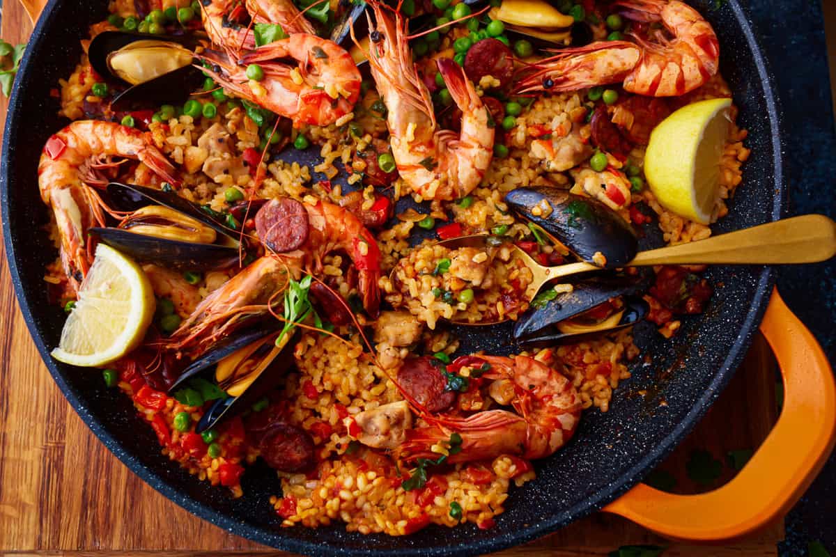 overhead view of a pan of paella with a serving spoon.