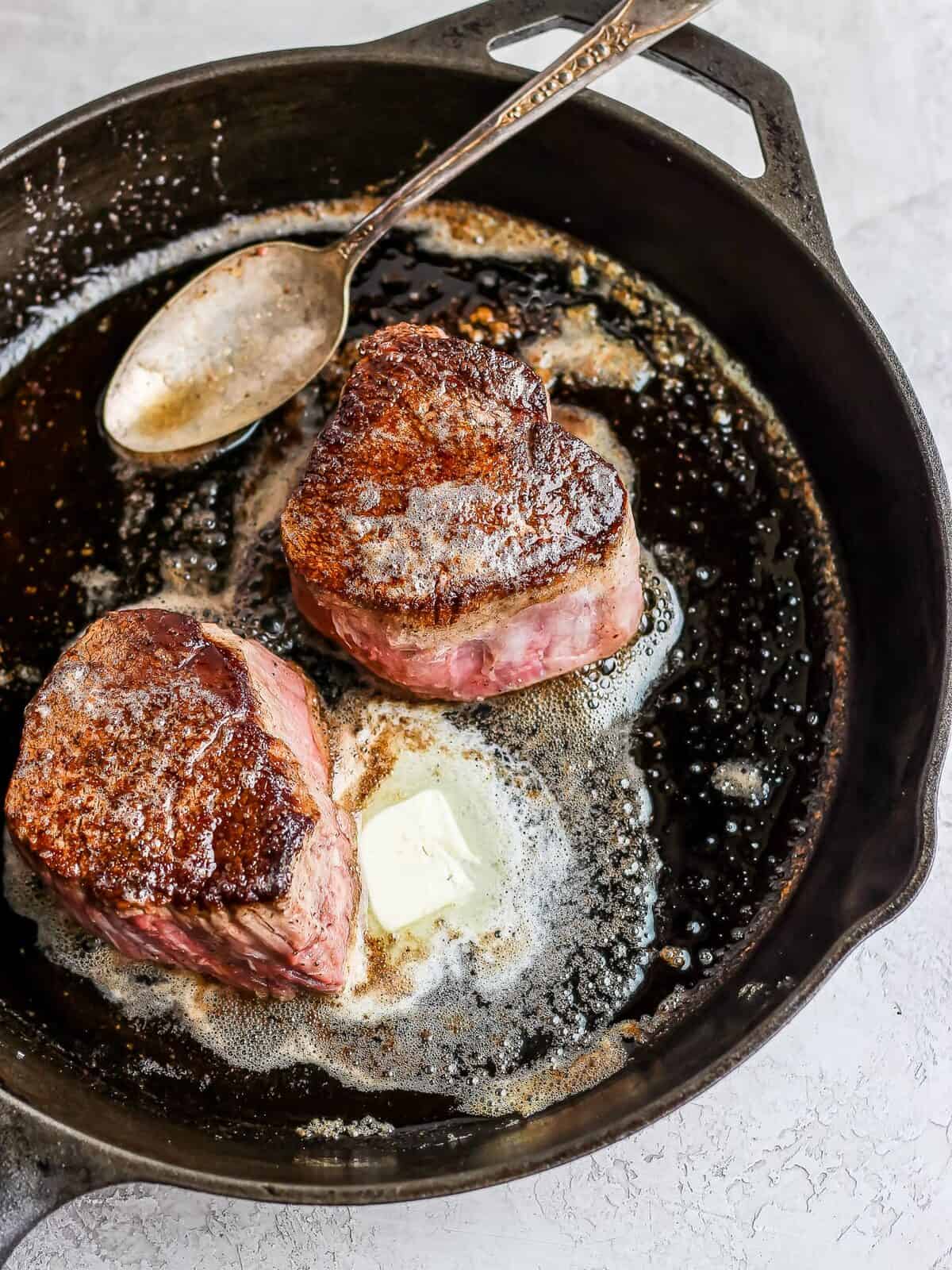 filet mignon cooking in a skillet