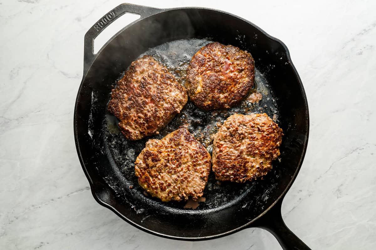searing cube steaks in a pan.