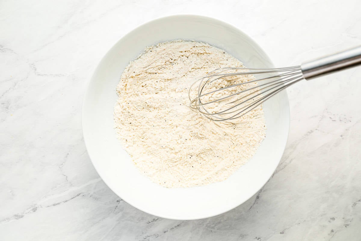 spices and flour in a bowl with a whisk.