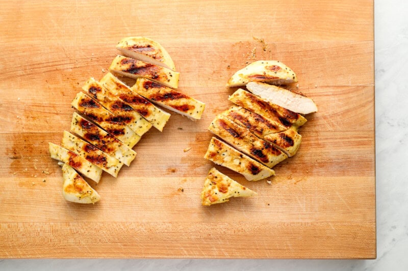 sliced grilled chicken breasts on a cutting board.