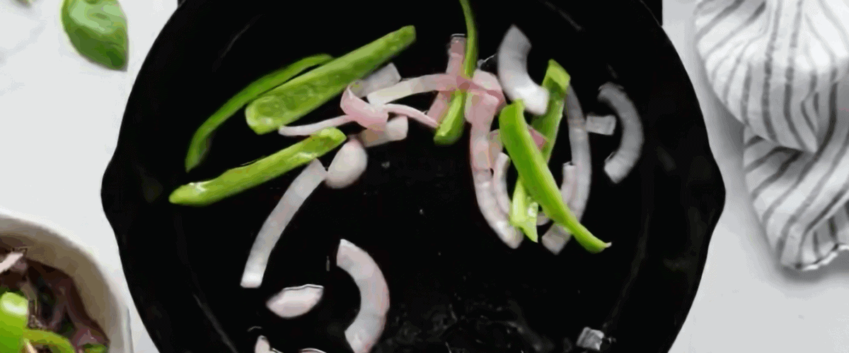 Cooking onion and green pepper in a skillet. 