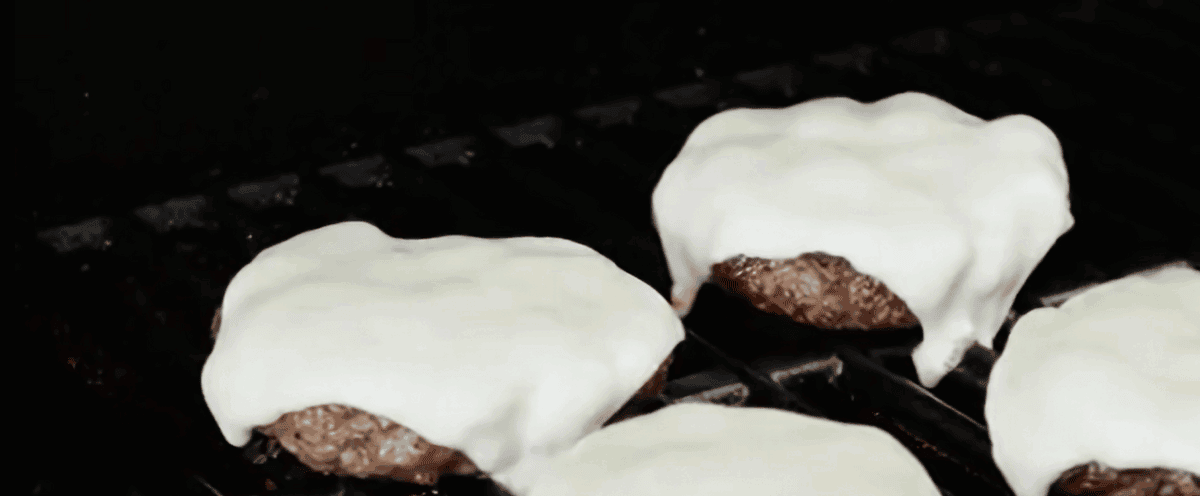 Burgers with cheese on a grill. 