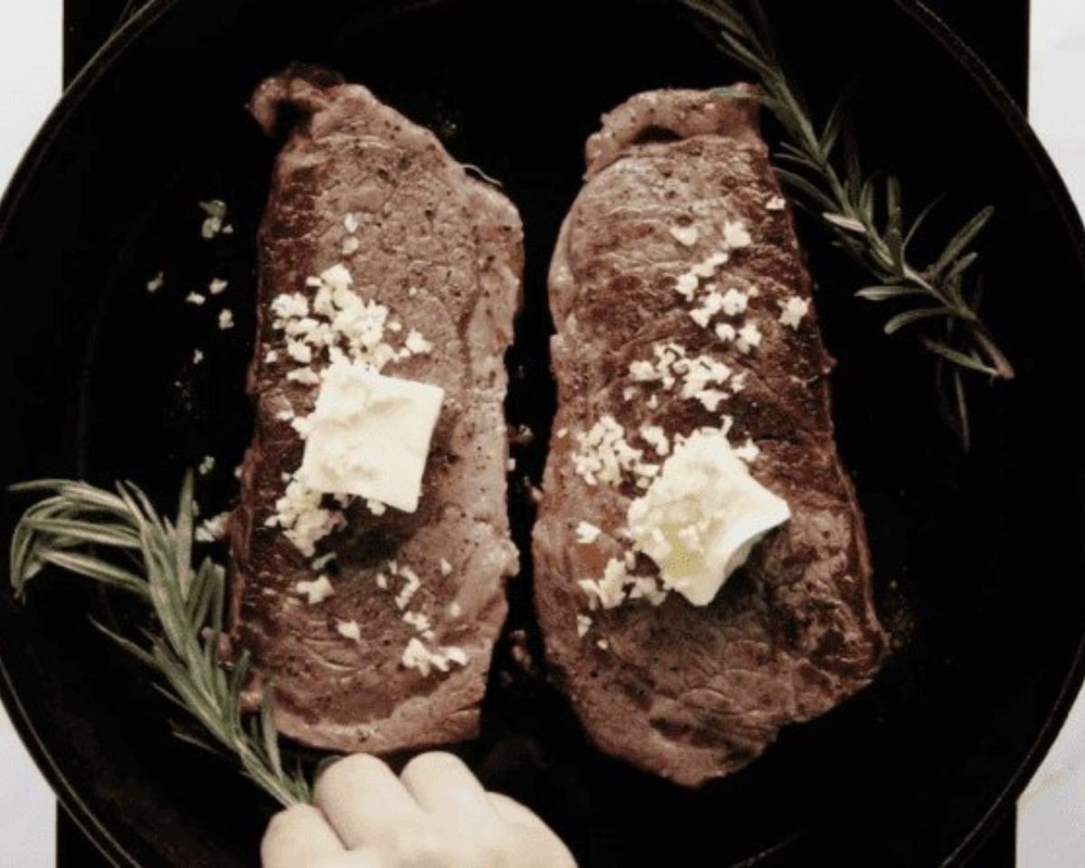 Adding butter, garlic and herbs to the steak. - 12