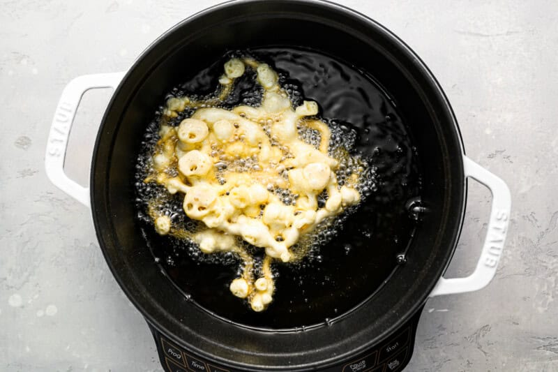 frying a funnel cake in hot oil.