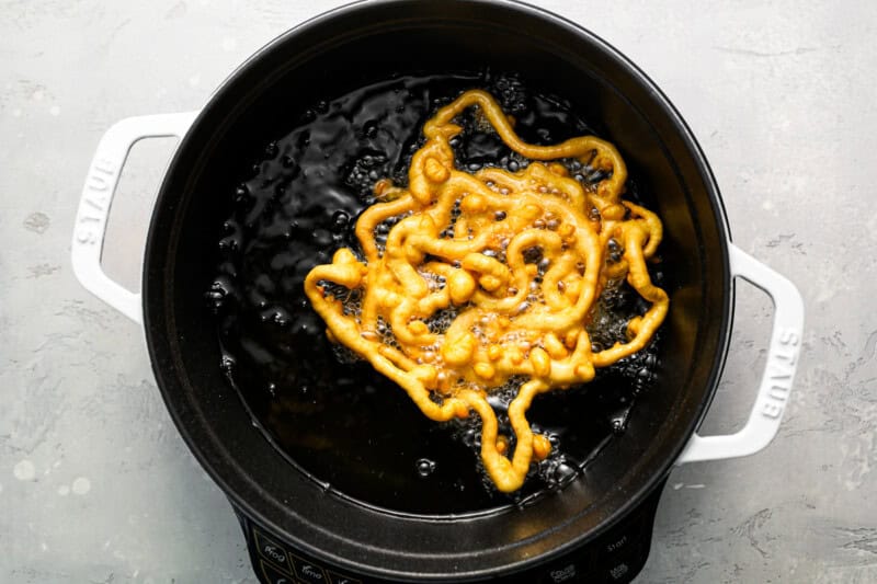 a fried funnel cake in hot oil.