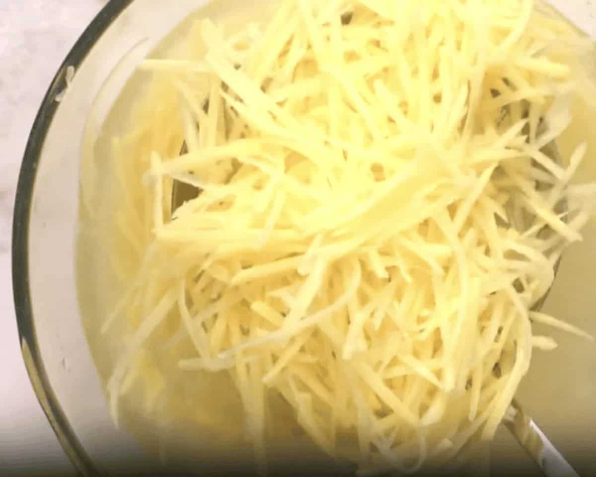 Soaking the cut potatoes in a bowl of water.