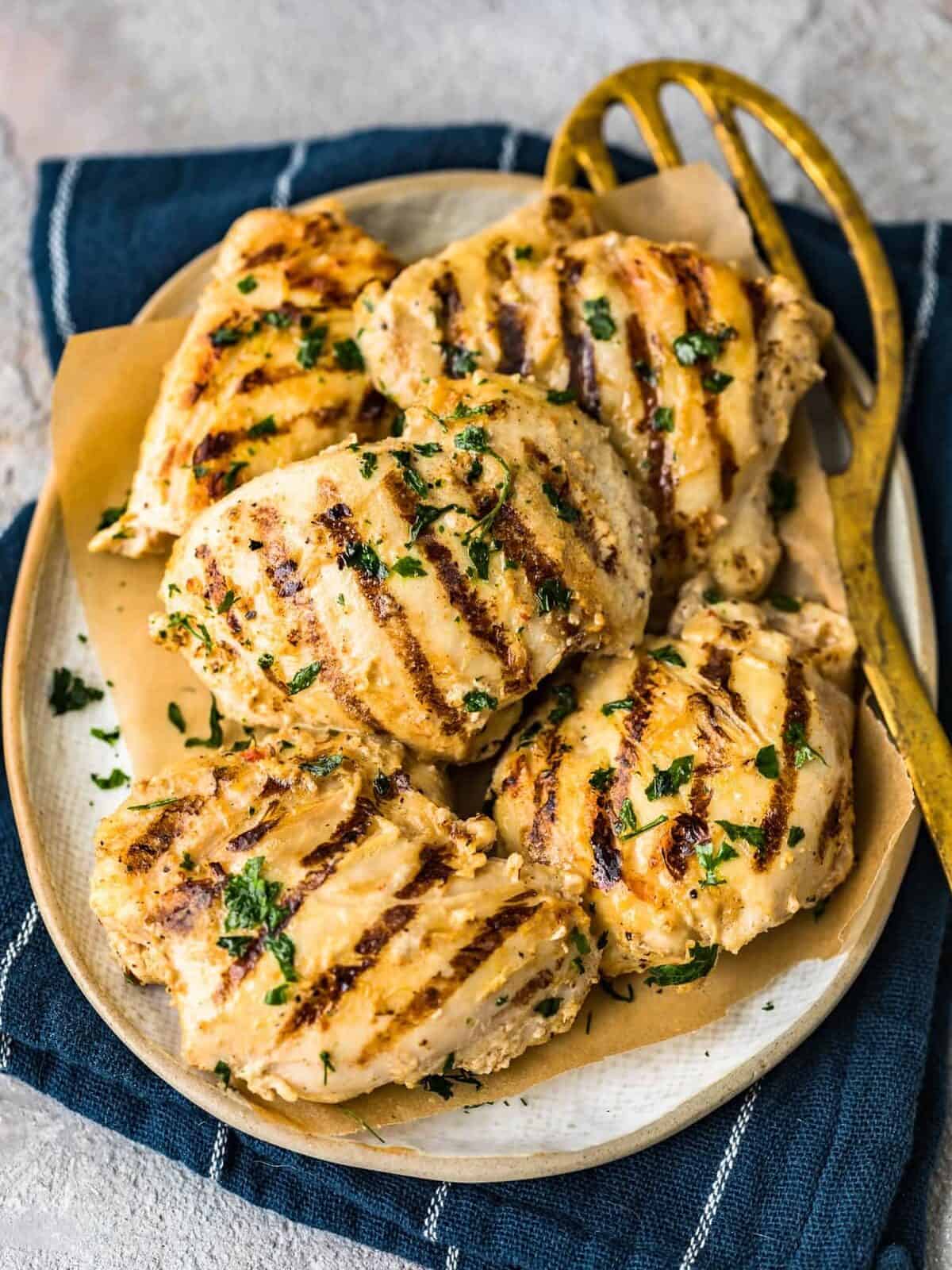 Yogurt Marinated Chicken Thighs are a quick and tasty recipe for weeknight dinners. This easy grilled chicken thighs recipe uses boneless, skinless chicken thighs and a delicious garlic, ginger, yogurt chicken marinade. Such an easy, healthy dinner idea for summer evenings! grilled chicken thighs on a plate