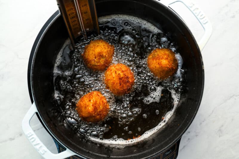 frying arancini in a dutch oven.