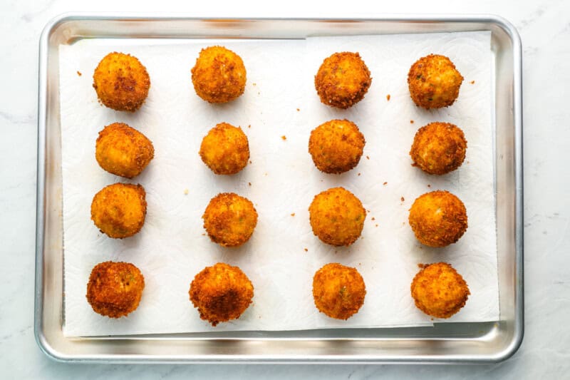 fried arancini on a baking sheet.