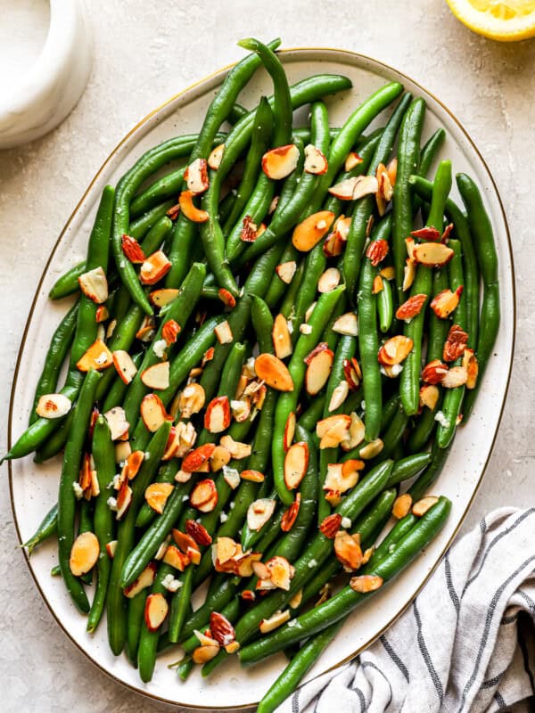 overhead view of green beans almondine on an oval platter.