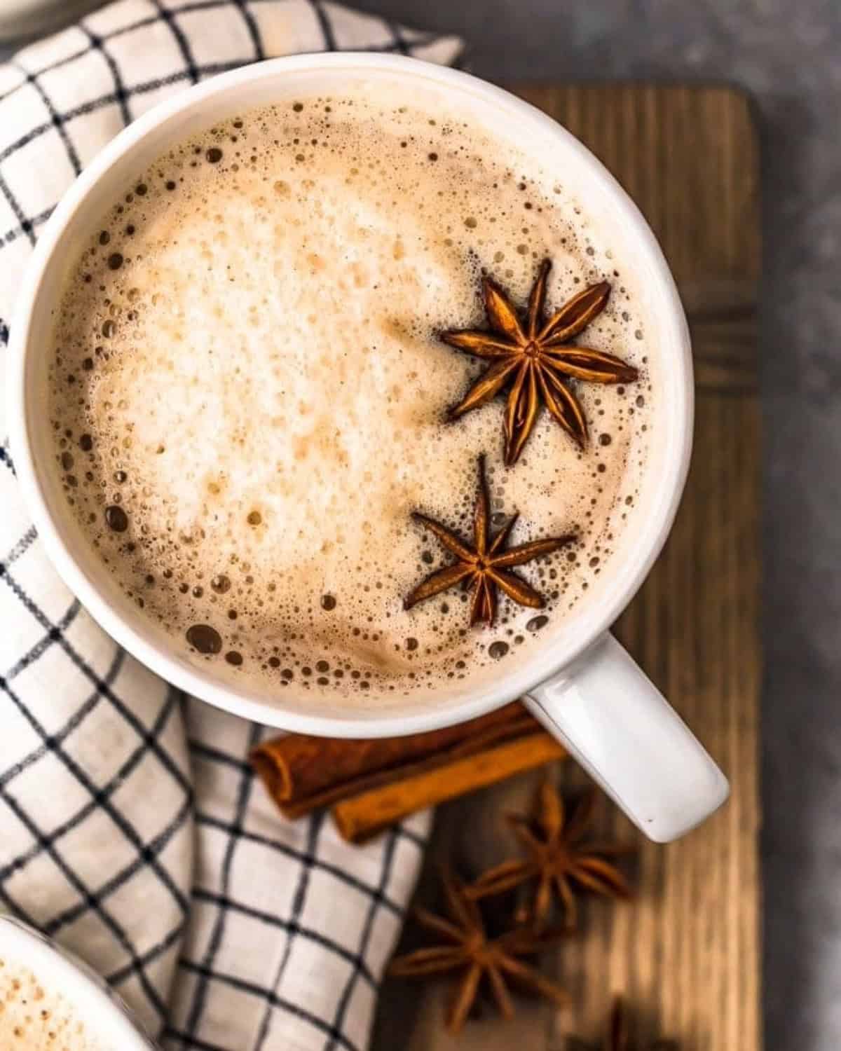 Spiked Chai is the perfect warm winter drink! This chai tea recipe is simple, delicious, and full of flavor. It's exactly what you need for Christmas parties or any chilly evening. We made it with bourbon, but it can also be made without alcohol. Overhead view of chai tea latte with bourbon in a mug, with star of anise floating on top.